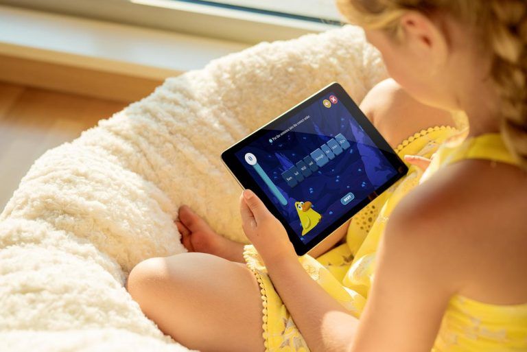 Girl with iPad playing on Night Zookeeper.